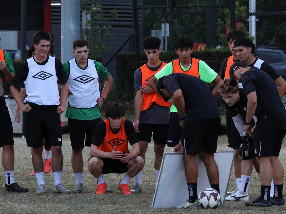Coach running a tactics session with development players